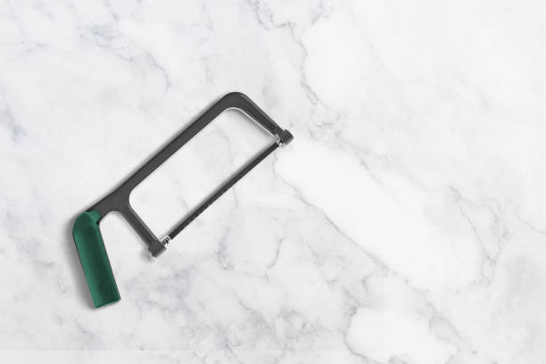 Close up photo of a man’s arm holding a Hand saw in front of white background