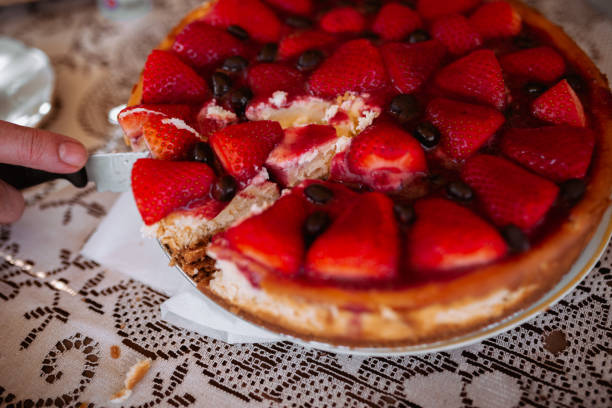 woman hand cutting strawberry cake with knife