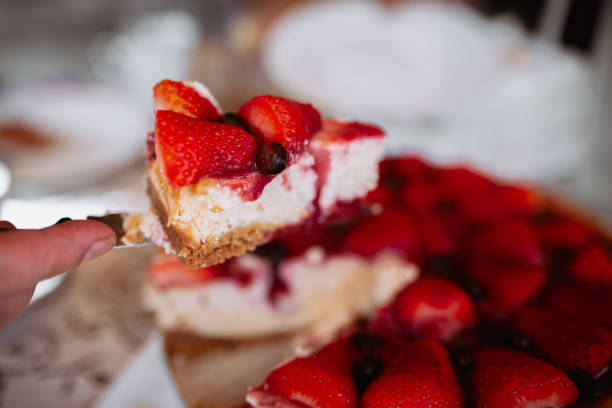 istock woman hand cutting strawberry cake with knife 2156388526
