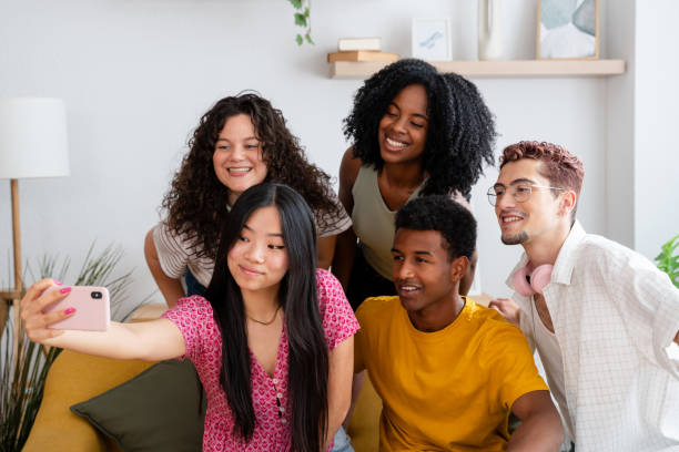 istock Diverse group of young adults posing for a joyful selfie at home 2156392486