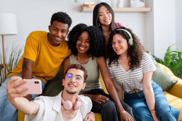 istock Five friends of different ethnicities happily posing for a selfie at home 2156392500