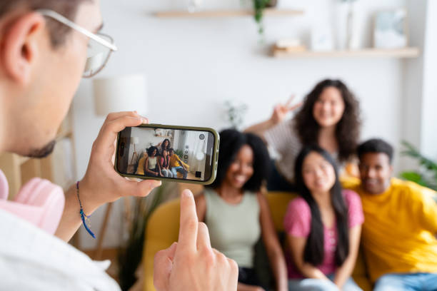 istock Photographer capturing his friends in a cozy home setting on a sofa 2156392536