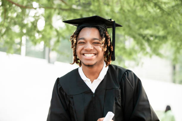 istock At his graduation, a striking young Black man beams at the camera. 2156394065