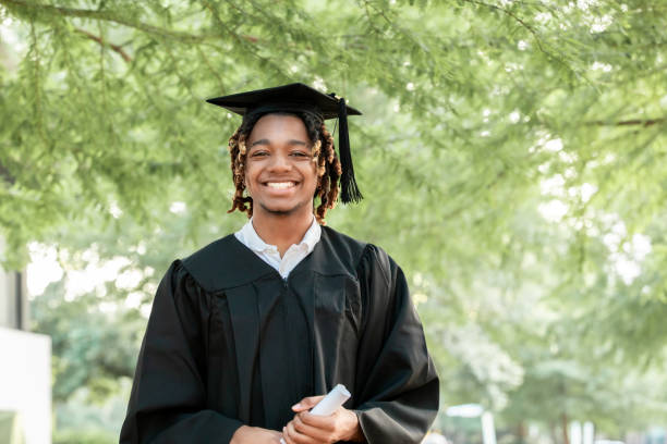 istock A handsome young black man smiles for the camera at his graduation. 2156394069