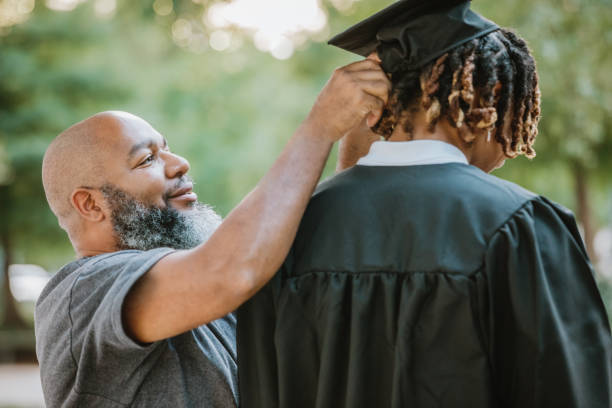 istock A dad helps his son adjust his mortarboard cap as he gets ready for graduation. 2156394103