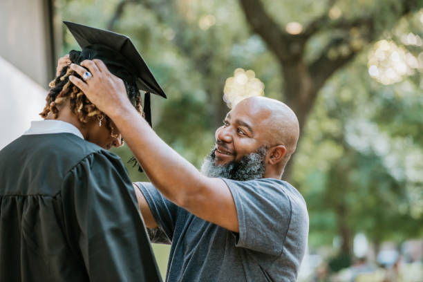 istock Helping his son with his mortarboard cap, a dad prepares him for graduation. 2156394107