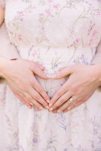 istock Pregnant mom makes a heart shape with her hands. 2156394544