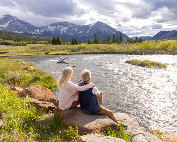 Senior couple relax on riverbank