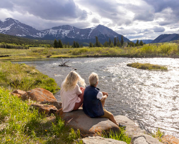 istock Senior couple relax on riverbank 2156397943
