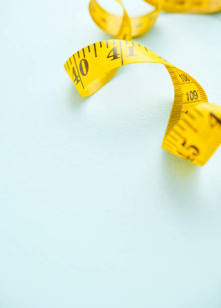 Yellow tape measure on a blue background with space for text