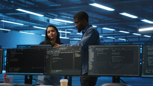 istock Multiethnic team of engineers in data center uses laptop to do programming 2156401695