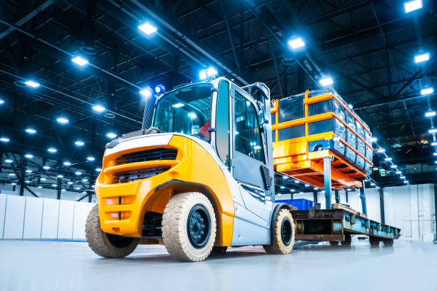 istock Diesel loader carries industrial lift with a load. Warehouse loader for transportation of containers. Loading oversized cargo. Transportation of industrial equipment. Special machinery. 2156403541