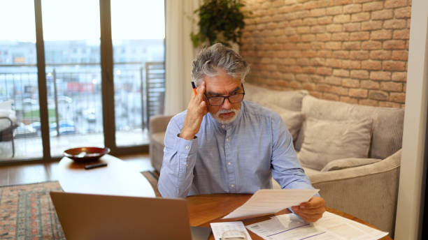 istock Mature man counting his costs 2156404032