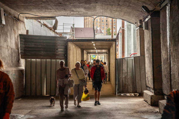 Riga, Latvia - August 23, 2023: Picture of latvian people walking in a tunnel underground under a bridge in the city center of Riga, Latvia. This image features Latvians walking by a tunnel, providing a snapshot of everyday life in Latvia. The photograph captures the movement and interactions of people in an urban setting, reflecting the social dynamics and cultural atmosphere of the area. Tunnels and pedestrian pathways are common features in Latvian cities, facilitating safe and convenient travel for residents and visitors. This image highlights the importance of urban infrastructure in daily life, showcasing the blend of traditional and modern elements that characterize Latvian society. The candid nature of the photograph adds to its authenticity and relatability.
