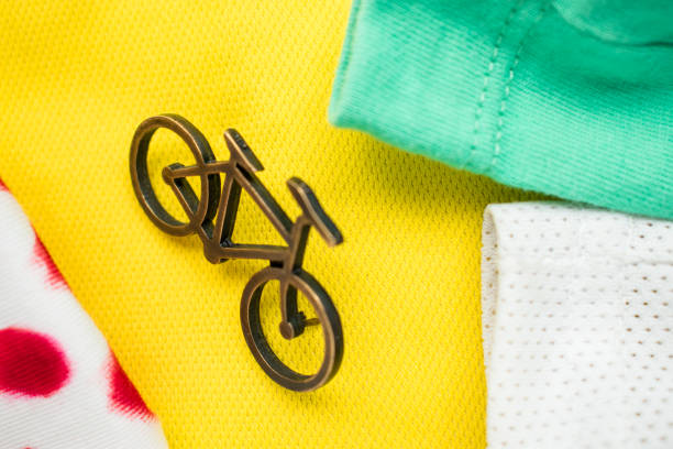 High angle view of bycicle pin on yellow background with some green, white and white with red points t-shirts