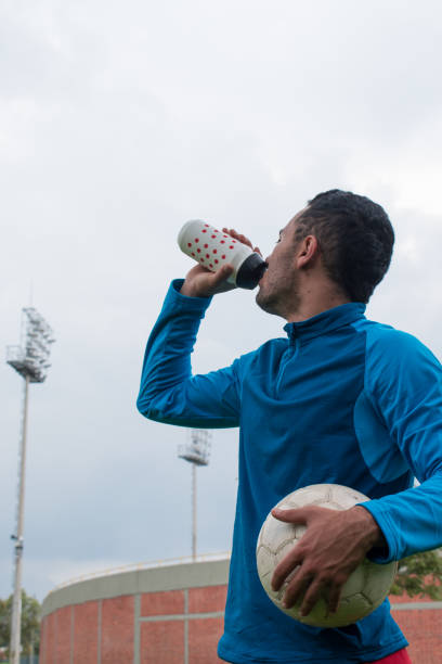 istock Soccer player drinking water from a plastic bottle in park 2156417646