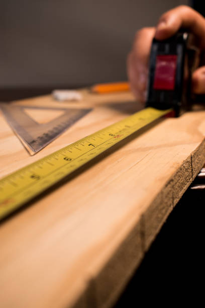istock Carpenter taking wood measurements 2156419385
