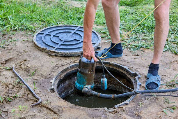 istock Worker pumps sewage out of septic tank using submersible drainwater pump. 2156420326
