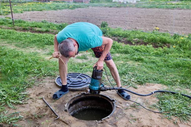 istock Septic tank is an underground storage tank for sewage waste, worker pumping  wastewater with sewer pump. 2156420328