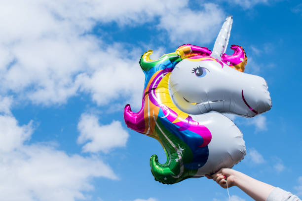 istock Hands rising a colorful unicorn balloon 2156420614