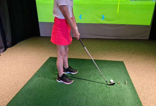 istock Woman in Pink Skirt Practicing Golf Swing on Indoor Course 2156426793
