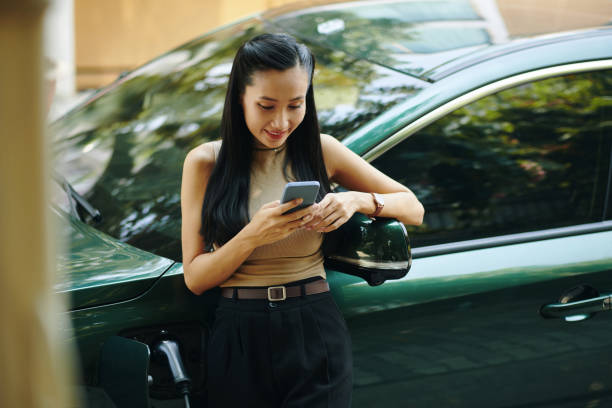 istock Woman Waiting for Car to Charge 2156430713
