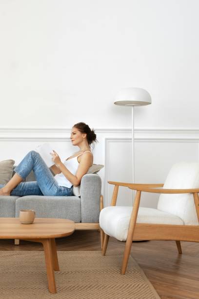 istock Woman reading a book in a minimal home 2156433395