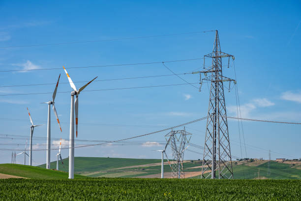 istock Electricity pylons with power lines and wind turbines 2156433455