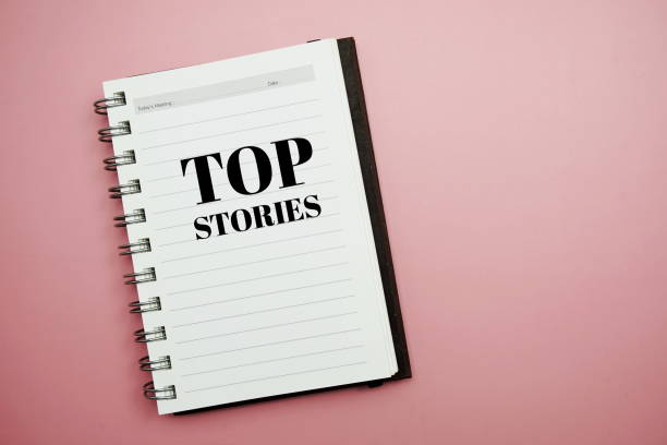 Top Stories text message typography text in a notebook on pink background