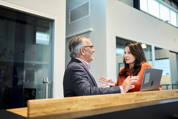 istock Smiling mature businesspeople working on a laptop during a sustainable resources conference 2156439005