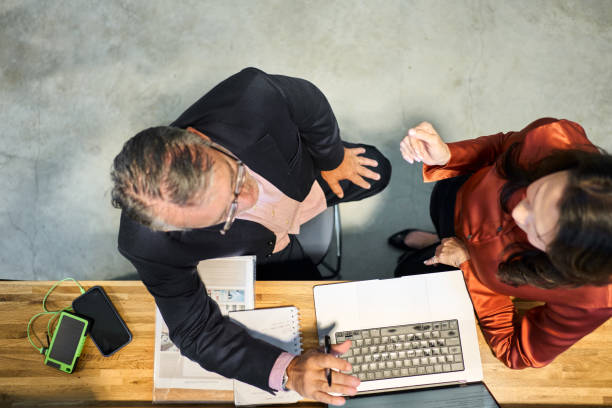 istock Mature businesspeople working on a laptop during a sustainable resources conference 2156439015