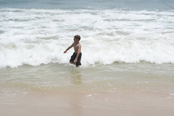 Boy plays in the sea at the beach.