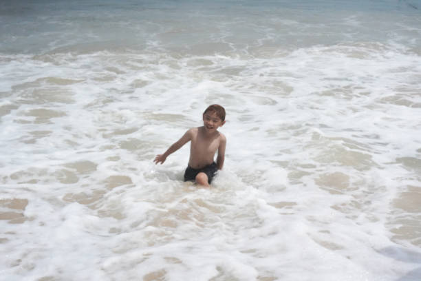 istock Boy plays in the sea at the beach. 2156439375