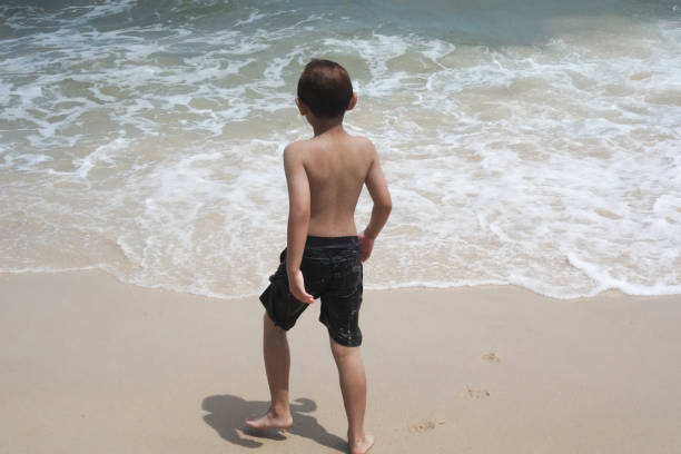 istock Boy plays in the sea at the beach. 2156439401