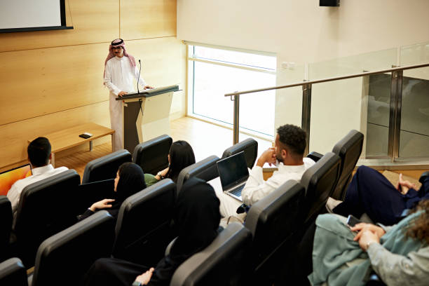 Professor speaking to students in auditorium