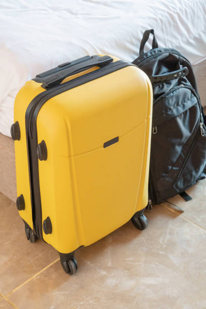 istock yellow suitcase on white wall background in hotel room 2156441186