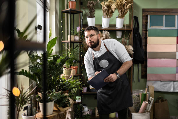 istock Young Florist Using Checklist in Modern Shop 2156441482