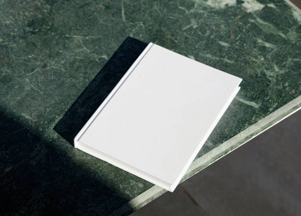 istock blank book mockup on green marble stone coffee table , shadow overlay 2156442341