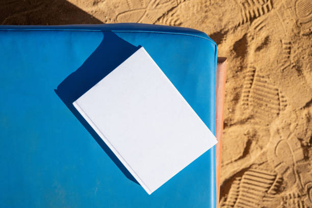 blank book mockup on lounge on sandy beach