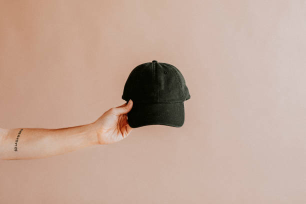 istock Tattooed arm holding a black cap 2156444447