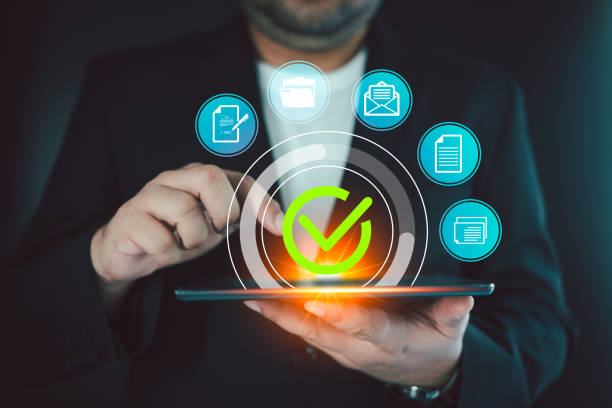 istock Businessmen touch a virtual glowing correct sign mark and document for online approval 2156446355