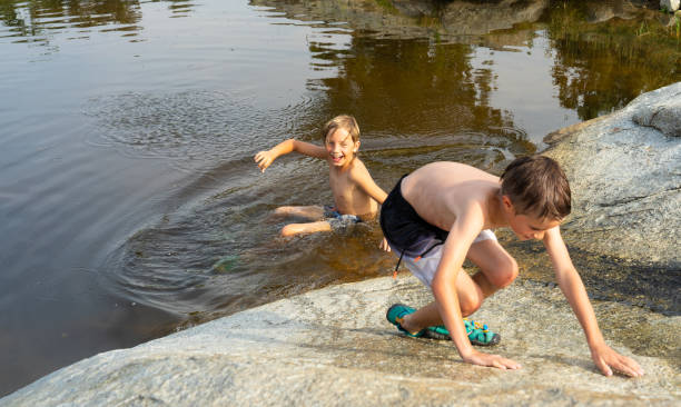 istock Two Caucasian boys 8 years old playing in a river in summer 2156450505