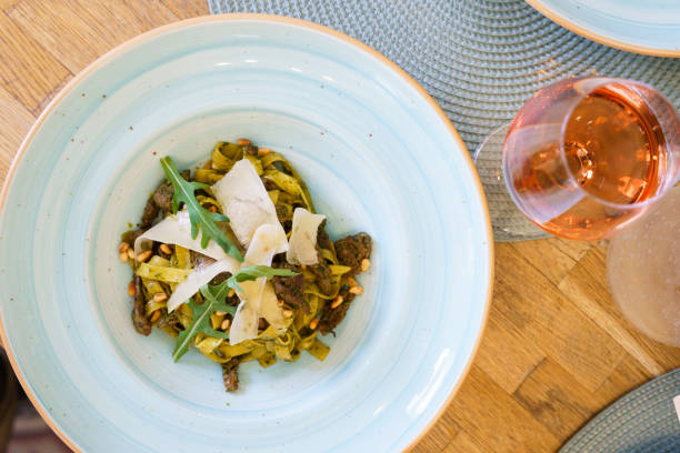 Pasta with pesto sauce and thin slices of cheese