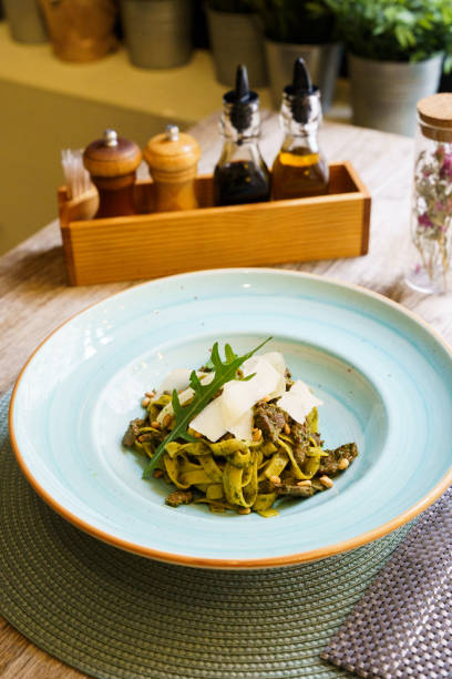 Pasta with pesto sauce and thin slices of cheese