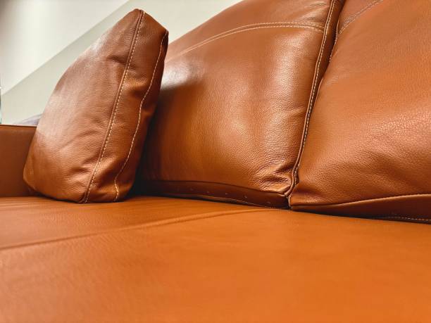 A brown tan leather settee sofa and cushions