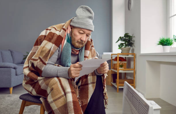 istock Senior man sitting at home and looking at the utility bill. Heating problems concept. 2156454303