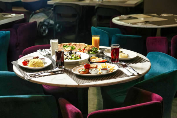 A table filled with plates of appetizing food and a selection of beverages for people to enjoy.