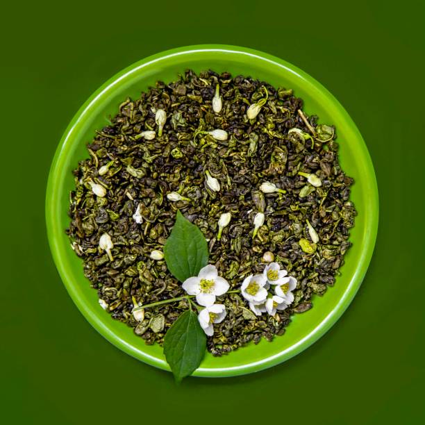 Herbal tea: variety of dried tea leaves and flowers for preparing healthy detox infusions shot on white table. The composition includes dried part of plants like hibiscus, calendula, rose petals, chamomile, bay leaves, cinnamon sticks, ginger, mint leaves and dried orange slices among others. A tea black teapot are also included. High resolution 42Mp studio digital capture taken with Sony A7rii and Zeiss Batis 40mm F2.0 CF lens