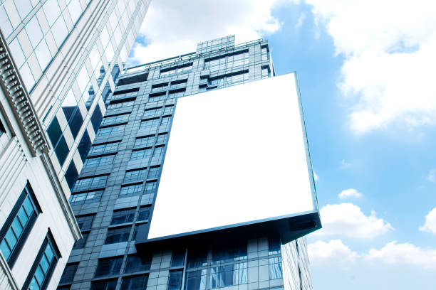istock Mock up white vertical large LED display billboard on tower building with blue sky background .clipping path for mockup 2156460821