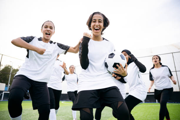 istock Happy female soccer team cheering with ball 2156461506